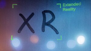 A window with a lot of condensation. The letters X R have been traced onto the window.