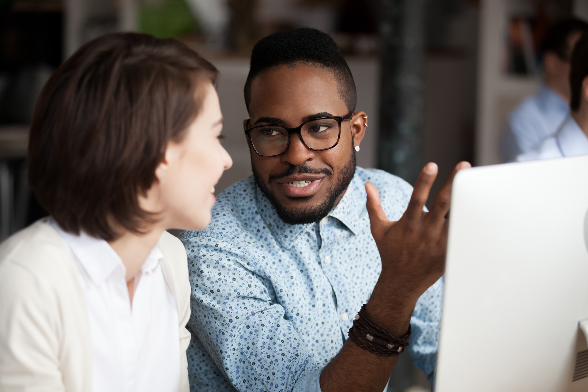 A woman and man are sitting side by side, enjoying a mentoring conversation.