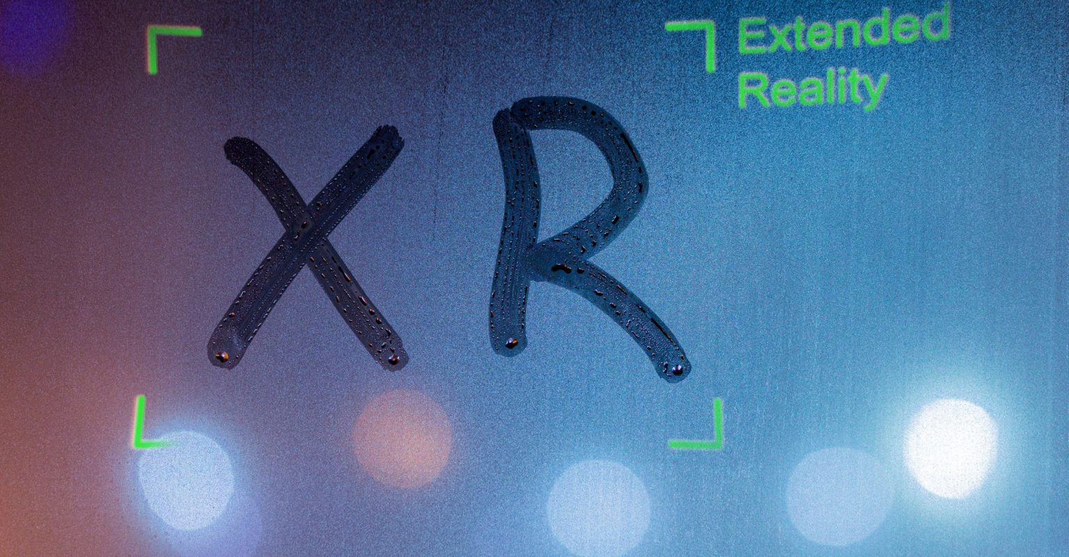 A window with a lot of condensation. The letters X R have been traced onto the window.