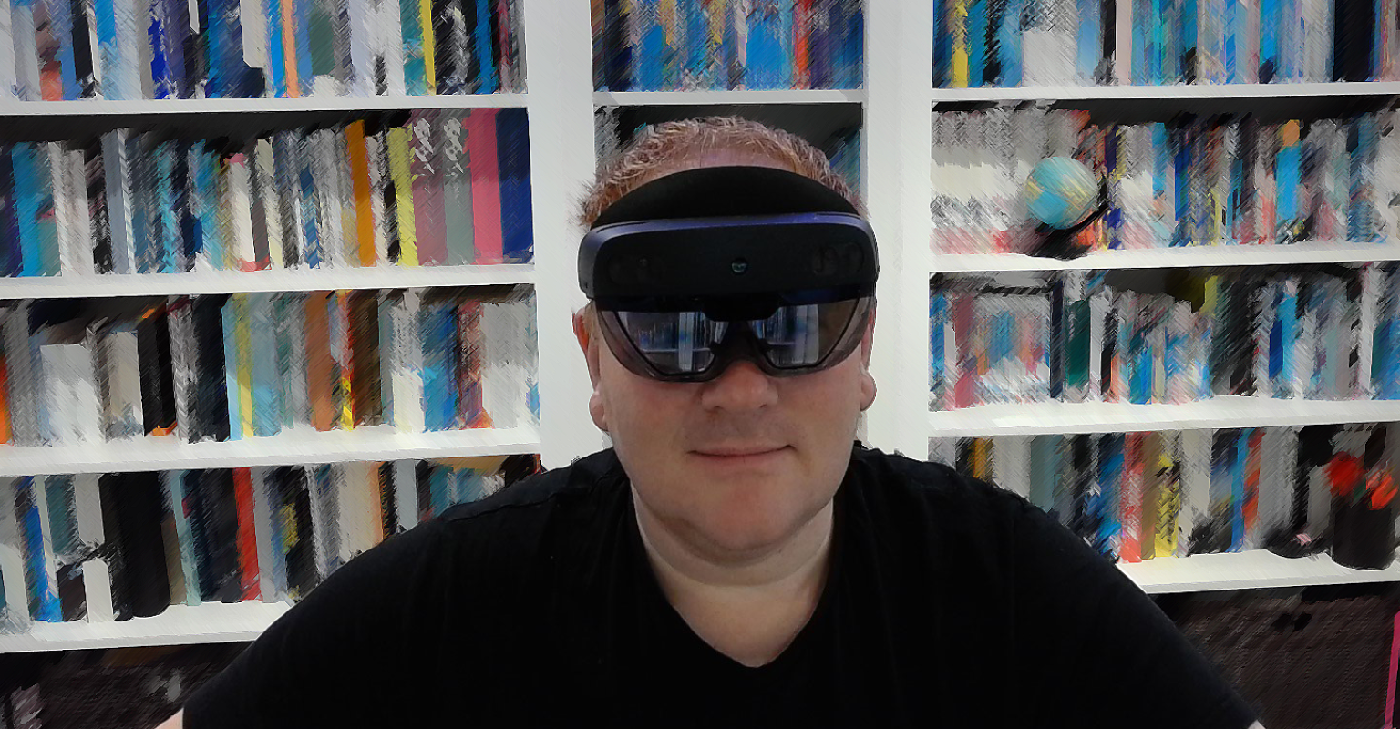 Richard Price, director of technology at the Learning Technology sits in front of a stylised bookcase, wearing a virtual reality headset.