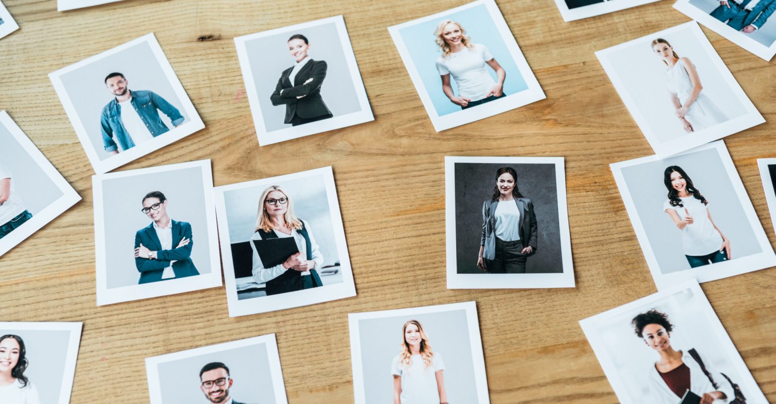 photos with men and women employees on wooden table